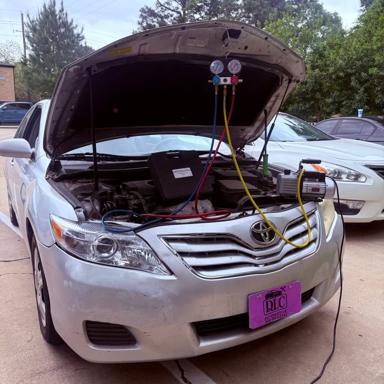 Silver Toyota Camry with open hood showing engine and diagnostic gauges connected for vehicle service