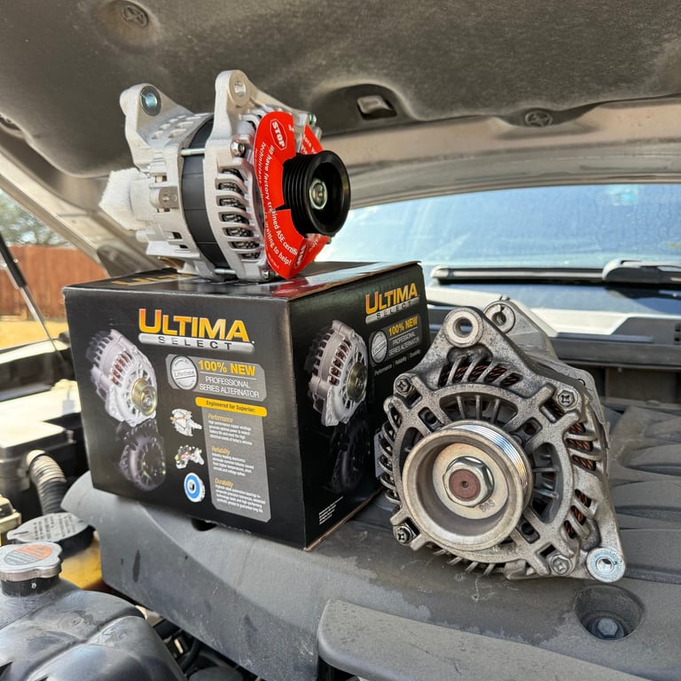 Two car alternators displayed on Ultima brand packaging in vehicle interior, one with red brake calipers and one silver with finned design